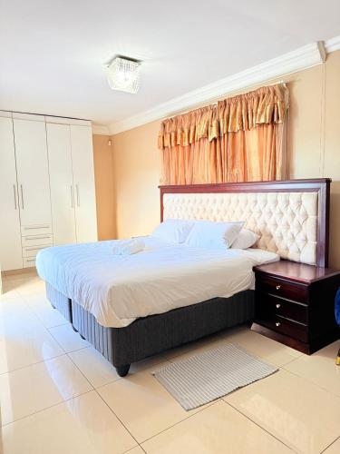 a bedroom with a large bed and a window at The Stillhouse Guest House in Edenvale