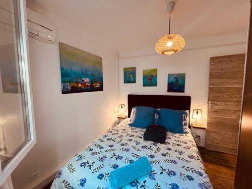 a bedroom with a bed with a blue comforter at Rivage hyper centre et plage a pied in Le Barcarès