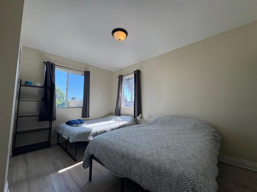 a bedroom with two beds and a window at Blue Urban Stay LA in Los Angeles