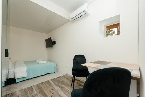 a bedroom with a bed and a desk and chairs at Studio Room Central in Chişinău