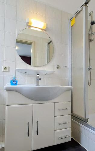 a bathroom with a white sink and a mirror at Hotel Münchner Löwenbräu in Cuxhaven