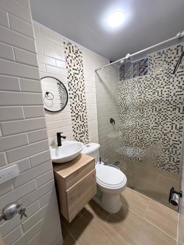 a bathroom with a toilet and a sink and a shower at Apartamento elegante en el Centro in Cocorná