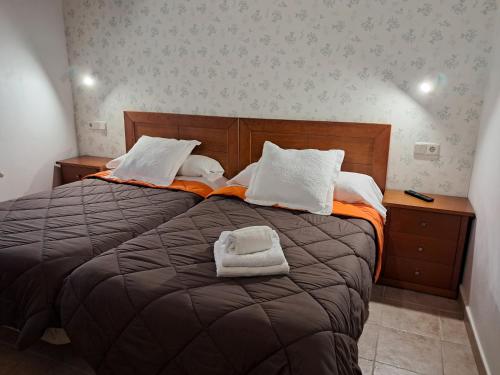 a bedroom with a large bed with two towels on it at La orilla del sella in Cangas de Onís
