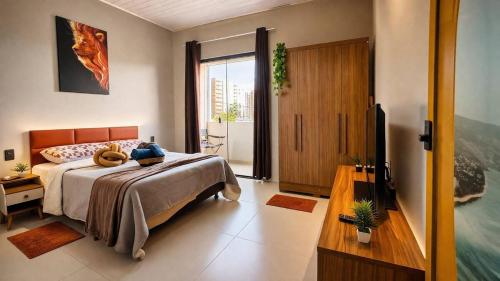 a bedroom with a bed and a television in it at Saborrrr Container - BOX 360 - Sobrado Alvenaria in Uberlândia