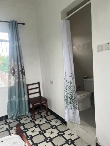 a bathroom with a bed and a shower and a chair at Amour Coco Stay in Chaki Chaki