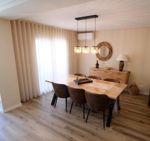 a dining room table with chairs and a mirror at Esmeralda house com garagem privada in Braga