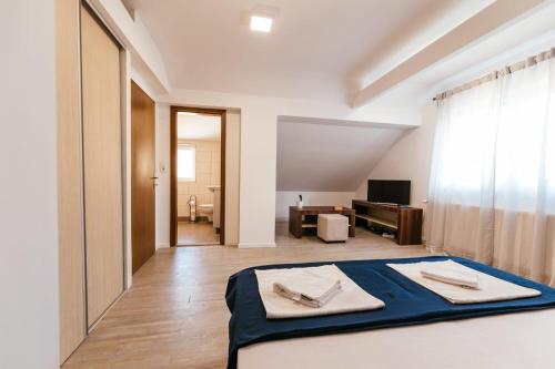 a bedroom with a bed and a living room at Apartment Stari Pazar in Konjic