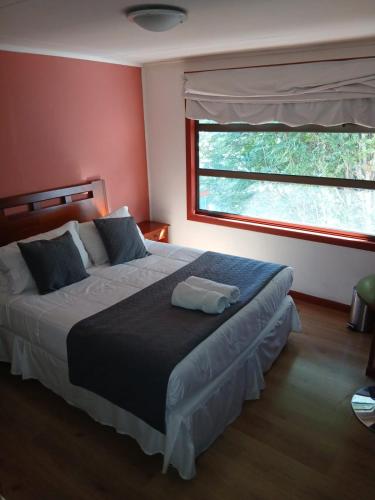ein Schlafzimmer mit einem großen Bett und einem Fenster in der Unterkunft Hotel Milodon in Puerto Natales