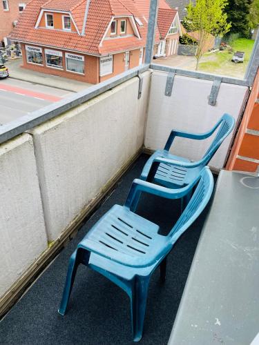 two blue plastic chairs sitting on top of a balcony at Monteur Apartment Lingen Zentrum in Lingen