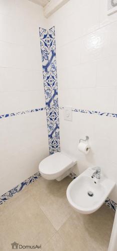 a white bathroom with a toilet and a sink at Domus Avi - Bed and Breakfast in Taviano