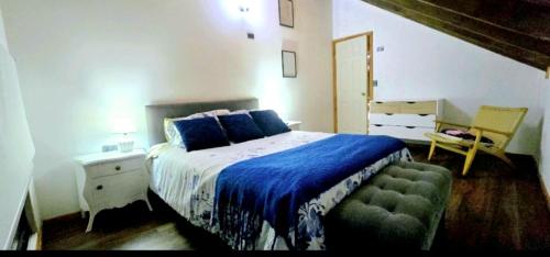 a bedroom with a bed with a blue blanket and a table at Casa Hortencia in Coñaripe