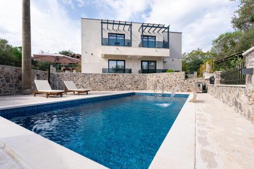 a house with a swimming pool in front of a house at Casa Bellavista in Tivat