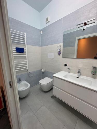 a bathroom with a sink and a toilet and a mirror at Blue Sea Salerno in Salerno