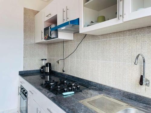 a kitchen with white cabinets and a stove top oven at Rieti Yamehome in Yaoundé