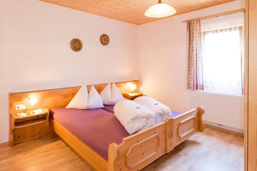 1 dormitorio con cama de madera y almohadas blancas en Gasthof-Pension Waldfriede, en Liesing