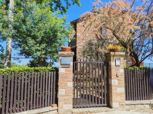 a brick fence with a gate in front of a house at Il Casale del Priore in Todi