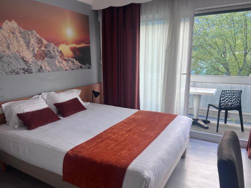 a bedroom with a bed and a large window at The Originals City, Hôtel Villancourt, Grenoble Sud in Le Pont-de-Claix