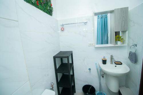 a white bathroom with a sink and a toilet at 206 Executive Granvia Suites in Cagayan de Oro