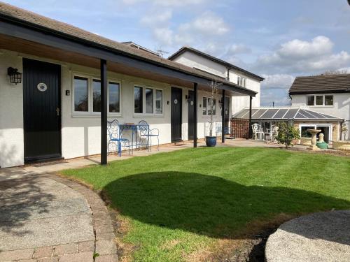 a house with a lawn in front of it at Primrose Cottage Westhead in Westhead