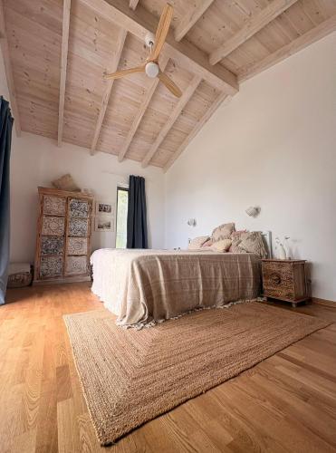 a bedroom with a bed and a wooden ceiling at Villa Xalupi - Design-Villa mit Pool und Meerblick in Paleokastritsa