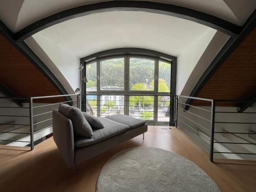 a living room with a couch and a large window at Urlaubsschmiede Mosel in Traben-Trarbach