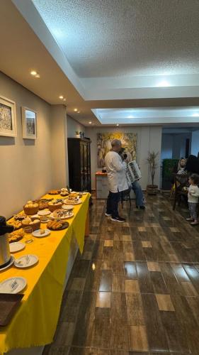 a group of people standing in a room with tables with food at Pousada Tropeira in Lapa