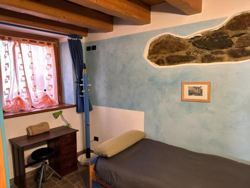 a bedroom with a bed and a desk and windows at Chalet La Terrazza Vista Lago in Bellano