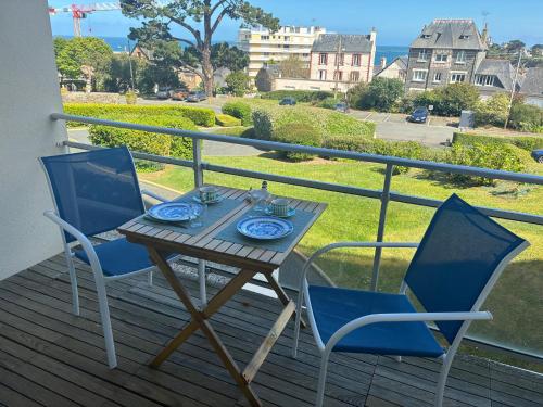 un tavolo e due sedie su un ponte con vista di Escapade Marine a Saint-Quay-Portrieux