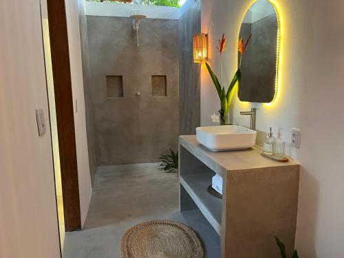 a bathroom with a sink and a mirror at Casa Ninho in Atins