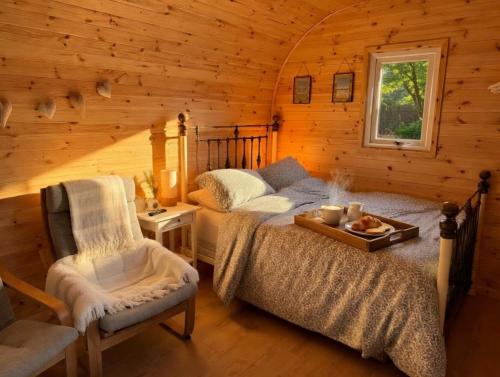 a bedroom in a log cabin with a bed and a chair at Avondale Lytham - Private Luxury Pod - Walk to Lytham Green in Lytham St Annes