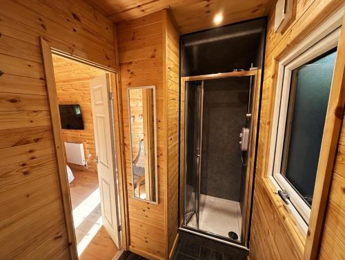 a walk in shower in a wooden room with a glass door at Avondale Lytham - Private Luxury Pod - Walk to Lytham Green in Lytham St Annes