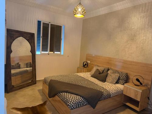 a bedroom with a bed and a large mirror at Tiwaline Tarsime App E in Sidi Ifni