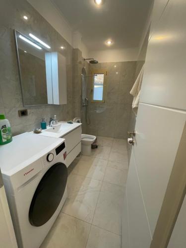 a bathroom with a white sink and a toilet at Makis & Lena's Home in Svoronata