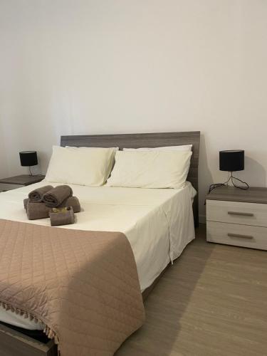 a bedroom with a large bed with white sheets and pillows at Sea Rocks House in Olbia