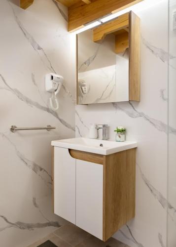 a bathroom with a sink and a mirror at KING rooms in Bečej