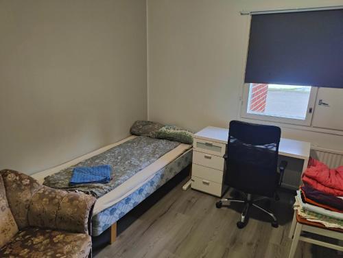 a bedroom with a bed and a desk and a chair at Paavolan Seimi in Paavola