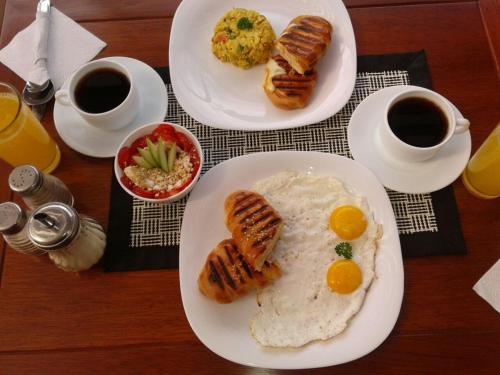 a table with two plates of breakfast food and two cups of coffee at ArtPlaza in Quito