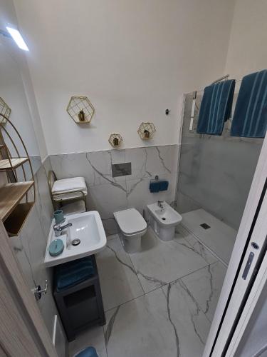 a white bathroom with a sink and a toilet at B&B Kasia in Palmadula