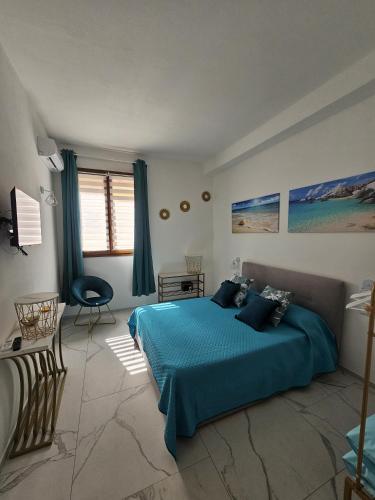 a bedroom with a blue bed and a chair at B&B Kasia in Palmadula