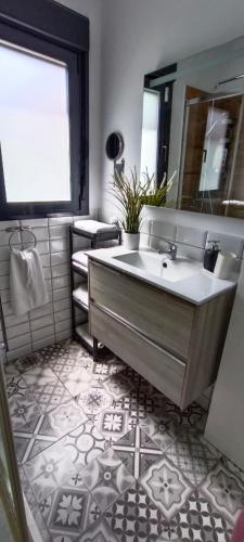 a bathroom with a sink and a large mirror at Angkor Wat Village in Puerto Real