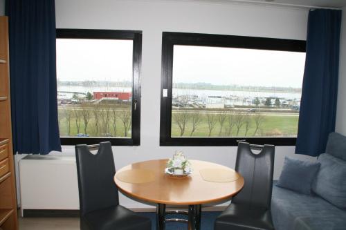 a dining room with a table and two windows at FW Knütel Nr 57 in Burgtiefe auf Fehmarn 