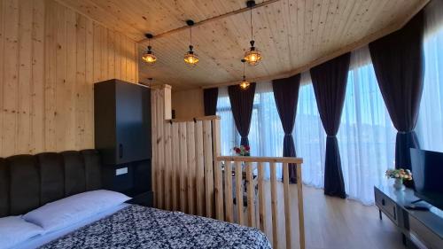 a bedroom with a bed and a tv and some windows at Eco Elegance in Makho