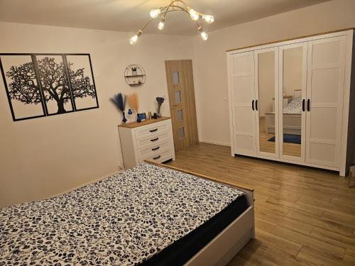 a bedroom with a bed and a dresser at Szybowcowa View Apartment in Jelenia Góra