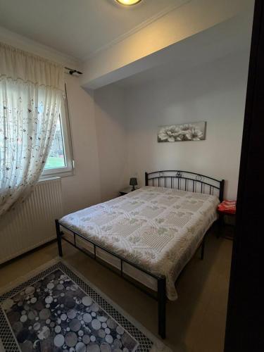 a bedroom with a bed and a window at Vila PANORAMA in Karianí