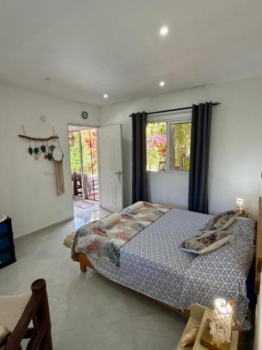 ein Schlafzimmer mit einem Bett und einem großen Fenster in der Unterkunft Meridiana in Las Terrenas