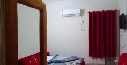 a mirror in a room with a red radiator at Eden Plus Executive Hotel Lahore in Lahore