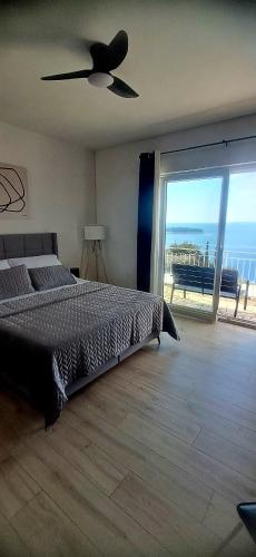 a bedroom with a bed and a view of the ocean at Apartmani Vesna Miliša in Primošten