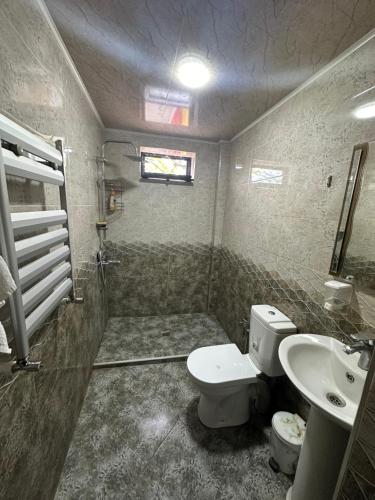 a bathroom with a toilet and a sink at Three Home in Quba