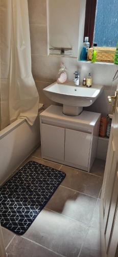 a small bathroom with a sink and a shower at Real Home In Northampton in Overstone