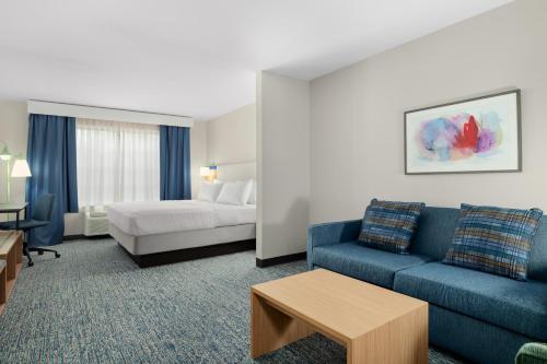 a hotel room with a couch and a bed at Garner Hotel Madison - Huntsville Airport by IHG in Madison